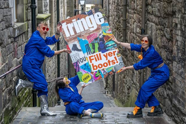 Cris Peploe, Claudia Cawthorne and Martha Haskins pose with a large-scale version of the Edinburgh Festival Fringe 2023 programme cover in the Old Town. Picture: Jane Barlow/PA Wire