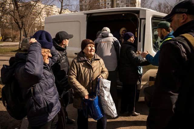Refugees are helped out of a van after fleeing the combat zone in the suburbs of the Ukrainian capital Kyiv.