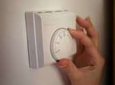 Undated file photo of a person using a central heating thermostat.