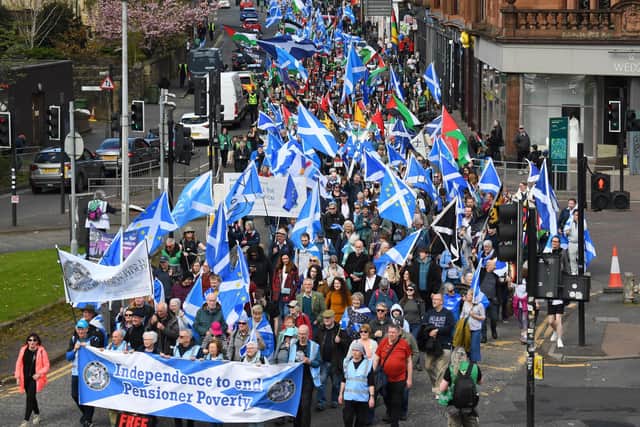 Protesters wave Scottish flags and hold placards as they march in support of Scottish independence in Glasgow earlier this year (Picture: Andy Buchanan/AFP via Getty Images)