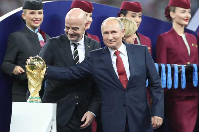 Russian President Vladimir Putin with the World Cup trophy and FIFA President Gianni Infantino.