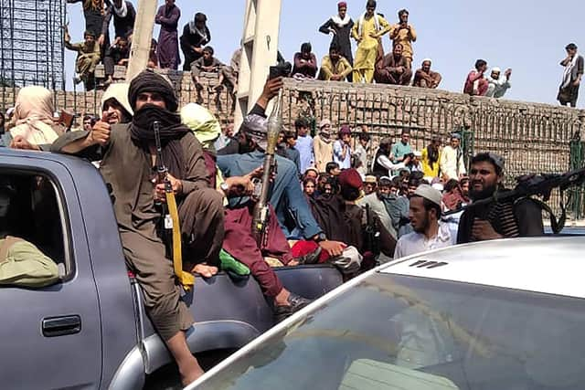 Taliban fighters sit on a vehicle along the street in Jalalabad province yesterday. (Photo by - / AFP) (Photo by -/AFP via Getty Images)