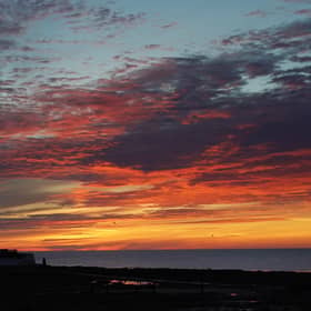 A orange sky just before sunrise at St Mary's Lighthouse in Whitley Bay. Picture date: Tuesday August 9, 2022.