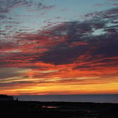 A orange sky just before sunrise at St Mary's Lighthouse in Whitley Bay. Picture date: Tuesday August 9, 2022.