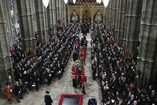 The coffin of Queen Elizabeth II is carried into Westminster Abbey for her funeral in central London.