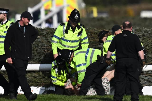 An animal rights protester is apprehended by police officers at the second fence ahead of the Grand National at Aintree last Saturday