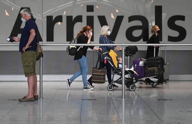 Passengers push their luggage on arrival in Terminal 5 at Heathrow airport in London.