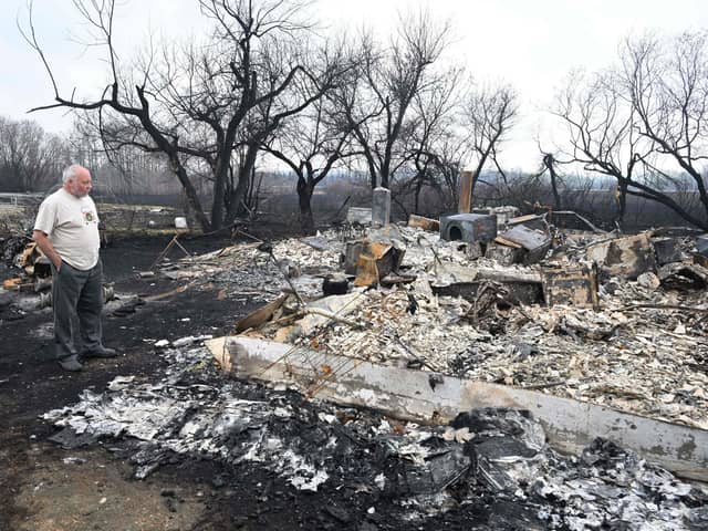 Adam Norris surveys the damage at his home near Drayton, Alberta, this week, after a wildfire swept through the area (Picture: Walter Tychnowicz/AFP via Getty Images)