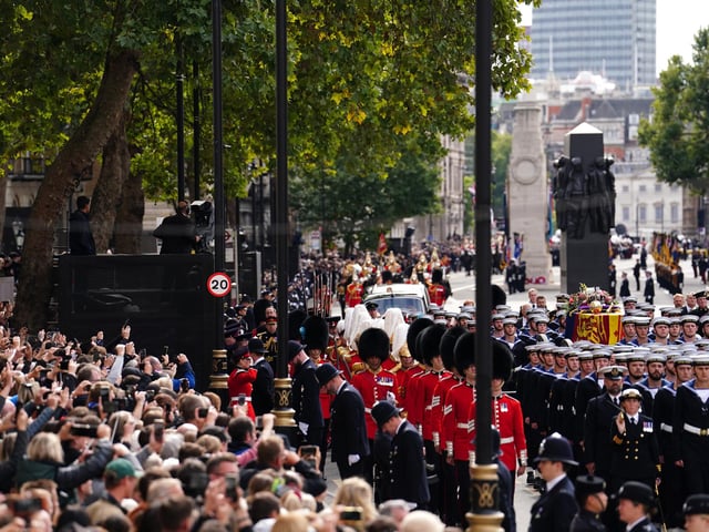 Crowds watch as the State Gun Carriage carries the coffin of Queen Elizabeth II, draped in the Royal Standard with the Imperial State Crown and the Sovereign's orb and sceptre, in the Ceremonial Procession following her State Funeral at Westminster Abbey, London. Picture date: Monday September 19, 2022.