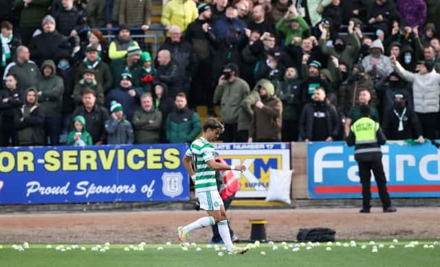 Celtic's Jota clears tennis balls from the pitch during the cinch Premiership match between Dundee and Celtic in November. (Photo by Alan Harvey / SNS Group)