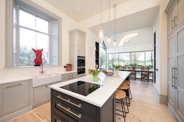 The kitchen flows through floor-to-ceiling windows and double sliding doors to a large, sheltered terrace and beyond to the garden, which overlooks the unspoilt parkland fields of Dalmeny Estate.