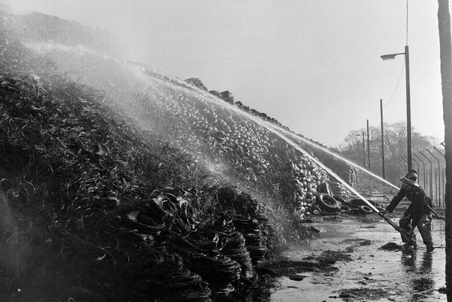 Firefighters spray water onto a pile of tyres that caught fire in the Edinburgh yard of the North British Rubber Company in April 1965.