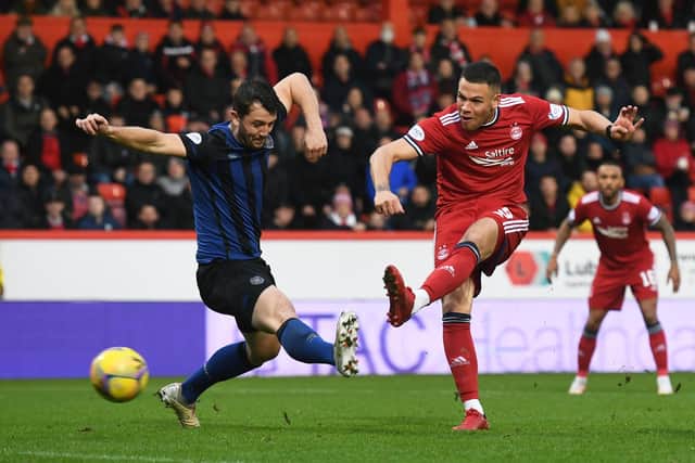 Aberdeen's Christian Ramirez shots as Hearts' Craig Halkett tries to block.