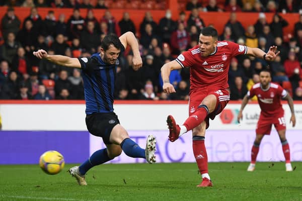 Aberdeen's Christian Ramirez shots as Hearts' Craig Halkett tries to block.