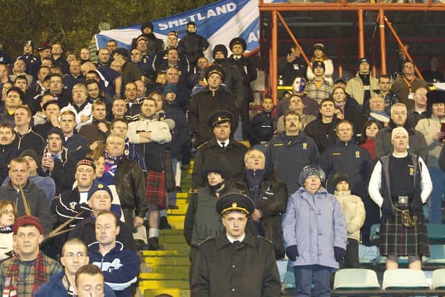 Under fire Scotland boss Berti Vogts watches from the stand during a 1-1 draw in Moldova in 2004 having recieved a touchline ban.