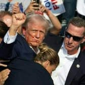 Republican candidate Donald Trump with blood on his face surrounded by secret service agents following an assassination attempt at a campaign event in Butler, Pennsylvania, July 13, 2024. PIC: Rebecca Droke /AFP/Getty Images
