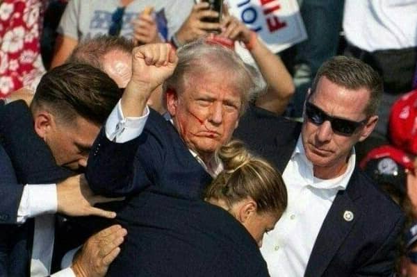 Republican candidate Donald Trump with blood on his face surrounded by secret service agents following an assassination attempt at a campaign event in Butler, Pennsylvania, July 13, 2024. PIC: Rebecca Droke /AFP/Getty Images