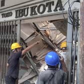 Workers inspect a store damaged during an earthquake in Cianjur, West Java, Indonesia, Monday, Nov. 21, 2022. An earthquake shook Indonesia's main island of Java on Monday damaging dozens of buildings and sending residents into the capital's streets for safety. (AP Photo/Firman Taqur)