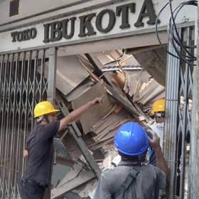 Workers inspect a store damaged during an earthquake in Cianjur, West Java, Indonesia, Monday, Nov. 21, 2022. An earthquake shook Indonesia's main island of Java on Monday damaging dozens of buildings and sending residents into the capital's streets for safety. (AP Photo/Firman Taqur)