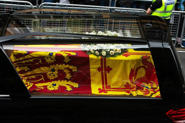 Queen Elizabeth II's coffin is removed from the vehicle at the Palace of Holyroodhouse in Edinburgh
