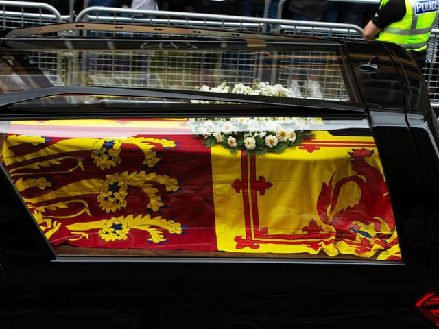 Queen Elizabeth II's coffin is removed from the vehicle at the Palace of Holyroodhouse in Edinburgh