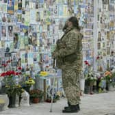 A serviceman mourns at the Memorial Wall of Fallen Defenders of Ukraine in Russian-Ukrainian War in Kyiv, Ukraine, Monday, Feb. 24, 2025. (AP Photo/Andrew Kravchenko)