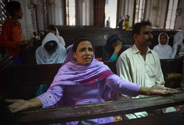 People mourn the deaths of those killed in a suicide bombing at the All Saints church in Peshawar in 2013 (Picture: A Majeed/AFP via Getty Images)