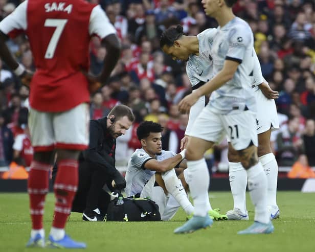 Liverpool's Luis Diaz receives medical staff help after injuring against Arsenal on Sunday.
