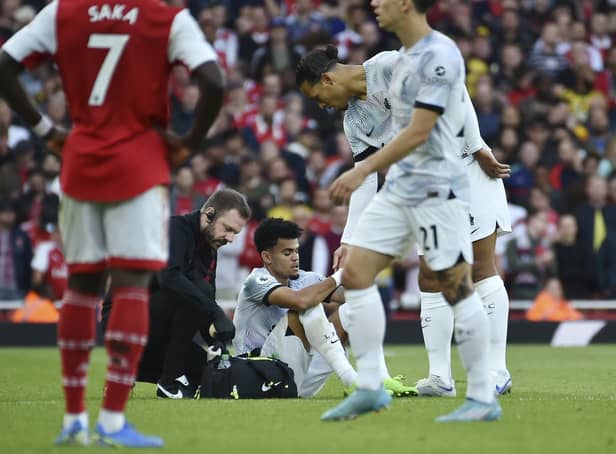 Liverpool's Luis Diaz receives medical staff help after injuring against Arsenal on Sunday.