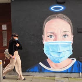 A woman walks past a mural in Manchester city centre. Cities in northern England and other areas suffering a surge in Covid-19 cases may have pubs and restaurants temporarily closed to combat the spread of the virus. Picture: Danny Lawson/PA Wire