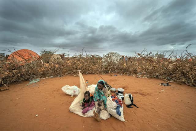 A Somali woman and child wait to be given a spot to settle at a camp for displaced people on the outskirts of Dollow in Somalia during the longest drought in the country's history, estimated to have killed 43,000 people