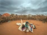 A Somali woman and child wait to be given a spot to settle at a camp for displaced people on the outskirts of Dollow in Somalia during the longest drought in the country's history, estimated to have killed 43,000 people