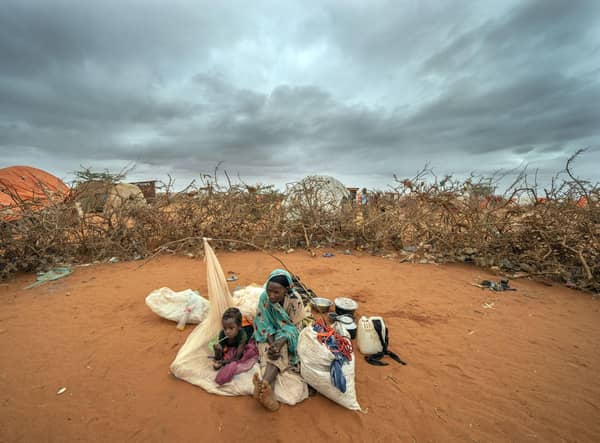 A Somali woman and child wait to be given a spot to settle at a camp for displaced people on the outskirts of Dollow in Somalia during the longest drought in the country's history, estimated to have killed 43,000 people