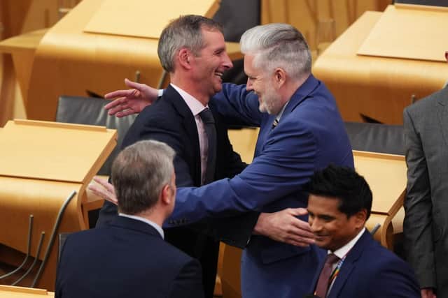 Liberal Democrat MSP Liam McArthur (left) is congratulated by MSP George Adam after MSPs approved the general principles of legislation which could introduce assisted dying for terminally ill Scots in a landmark vote in the Scottish Parliament in Edinburgh: Andrew Milligan/PA Wire