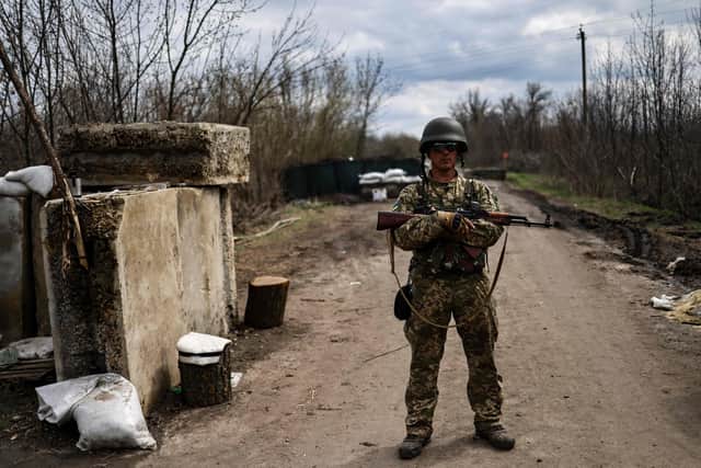 A Ukrainian serviceman stands guard at a checkpoint on the outskirts of Barvinkove, eastern Ukraine, on April 15, 2022.