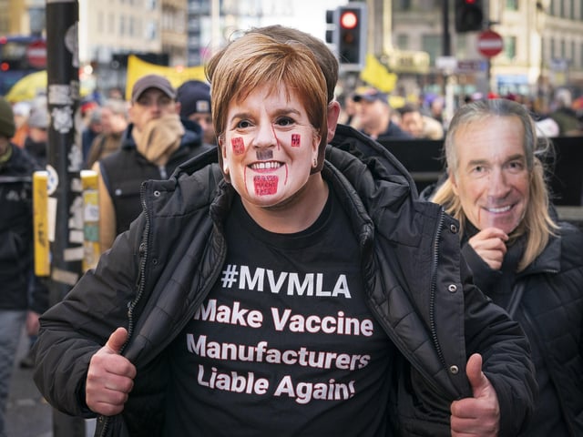 One protester wearing a Nicola Sturgeon mask and a T-shirt which reads: "Make vaccine manufacturers liable again!"