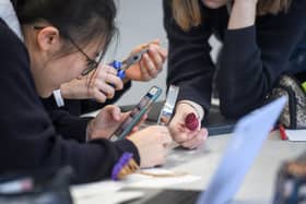 School pupils looking at their mobile phones