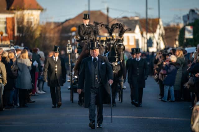 Members of the public pay their respects as the horse drawn hearse carrying the coffin of Sir David Amess, arrives at his constituency office at Iveagh Hall, in Leigh-on-Sea, following his funeral service. Picture: Aaron Chown/PA Wire