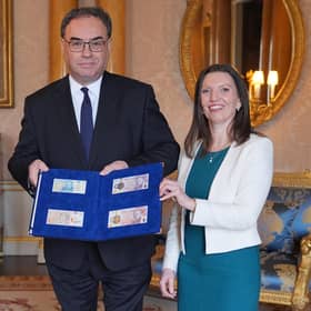King Charles is presented with the first bank notes featuring his portrait by Bank of England Governor Andrew Bailey and Sarah John, the bank's chief cashier (Picture: Yui Mok/WPA pool/Getty Images)