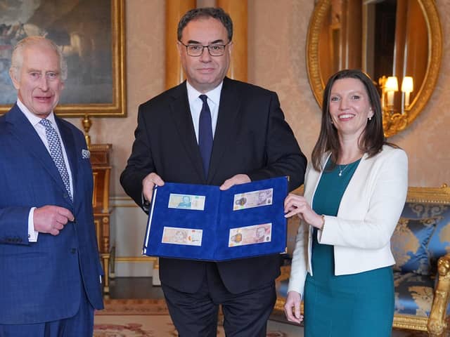 King Charles is presented with the first bank notes featuring his portrait by Bank of England Governor Andrew Bailey and Sarah John, the bank's chief cashier (Picture: Yui Mok/WPA pool/Getty Images)