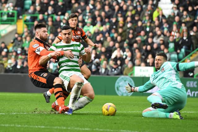 Benjamin Siegrist displays the form for Dundee United which earned him a move to Celtic, making a save from striker Giorgos Giakoumakis at Celtic Park in January. (Photo by Mark Runnacles/Getty Images)