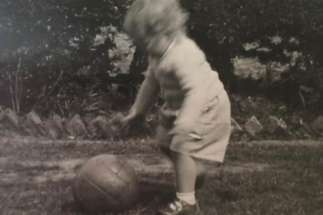 The faded black and white photograph of Susan Dalgety playing football as a toddler which makes her look to the past - but also the future. PIC: Contributed.