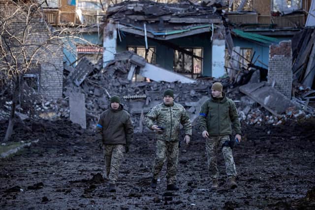 Servicemen walk near a damaged school, next to a police building in Kramatorsk, Donbas Region of eastern Ukraine