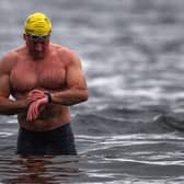 Open water swimming enthusiasts enjoy an early morning swim in Loch Lomond in Trossachs, Scotland.