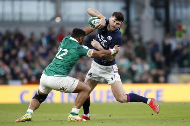 Scotland stand-off Blair Kinghorn tries to find a way past Ireland's Bundee Aki. (AP Photo/Peter Morrison)