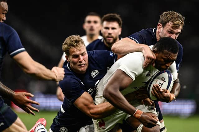 France's flanker Cameron Woki (C) is tackled by Scotland's wing Duhan van der Merwe during the match in Saint-Etienne.