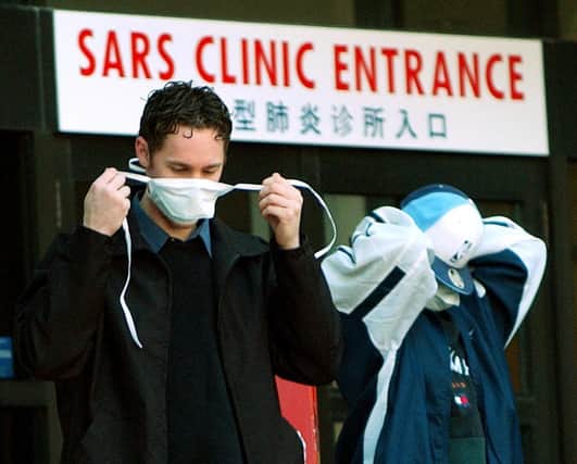 Patients put on face masks as they leave a SARS (Severe Acute Respiratory Syndrome) in Toronto, Canada in 2003 (Photo: J.P. MOCZULSKI/AFP via Getty Images)