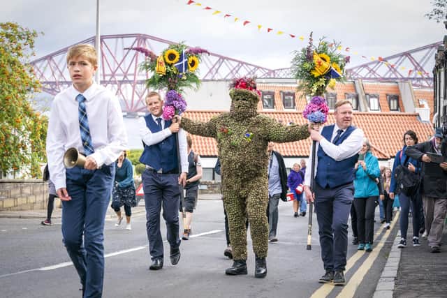 Burryman Andrew Taylor parades through the town of South Queensferry, near Edinburgh, encased in burrs.