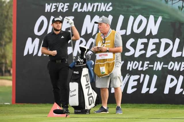 Tyrrell Hatton picks his club after receiving advice from Scottish caddie Mick Donaghy on the seventh tee in the second round of the Abu Dhabi HSBC Championship. Picture: Ross Kinnaird/Getty Images.