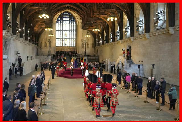 Guards are changed as members of the public file past the coffin of Queen Elizabeth II, draped in the Royal Standard with the Imperial State Crown and the Sovereign's orb and sceptre, lying in state on the catafalque in Westminster Hall - where her father George VI also lay - ahead of her funeral on Monday. PIC: Kirsty Wigglesworth/PA Wire